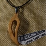veerhanger of gebogen blad van gewaxt melezehout handgemaakt ethisch sieraad